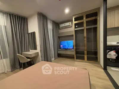 Modern bedroom with stylish decor, featuring a TV, desk, and mirrored wardrobe.