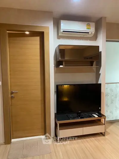 Modern living room with air conditioning and sleek TV setup in a stylish apartment.