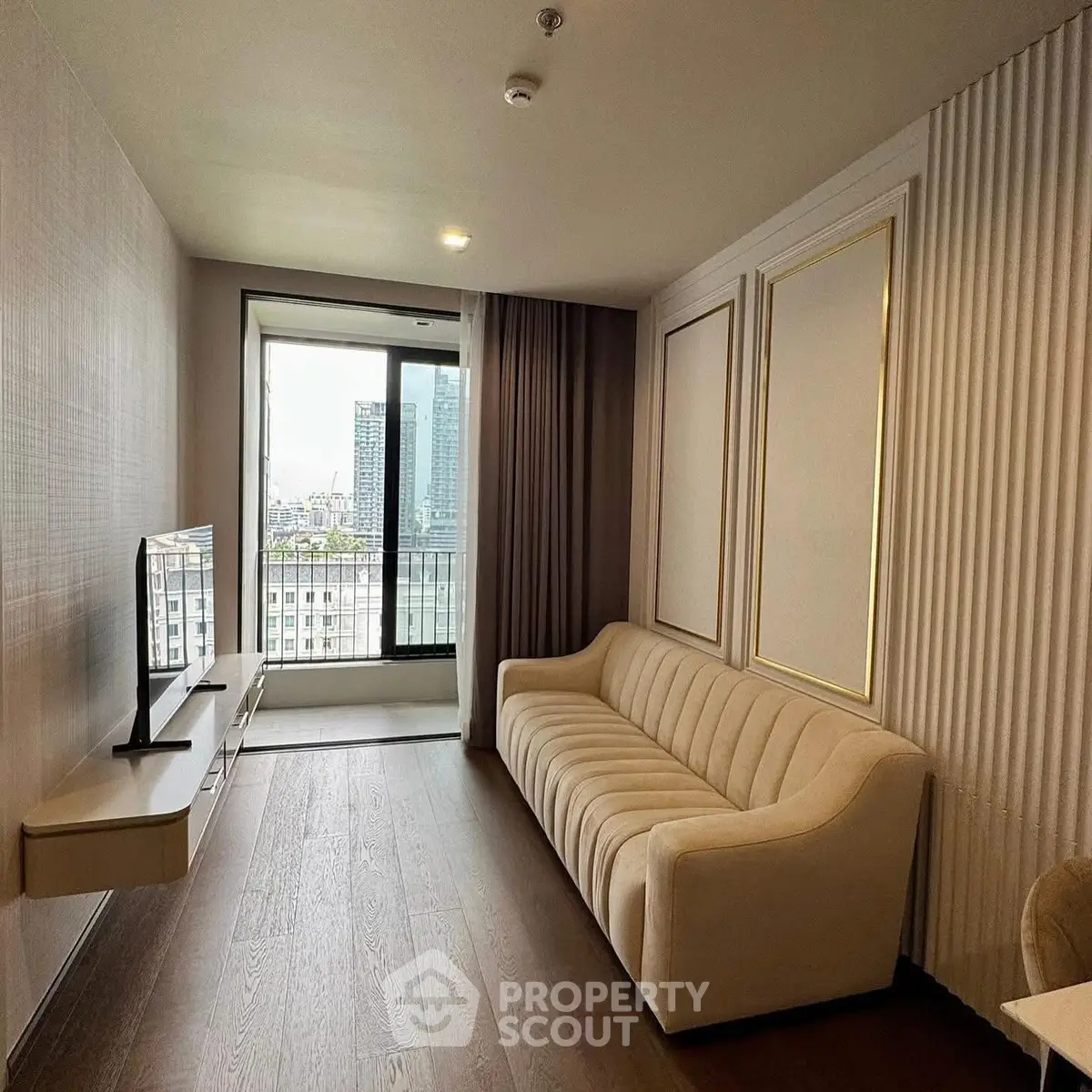 Modern living room with elegant sofa and city view balcony in high-rise apartment.