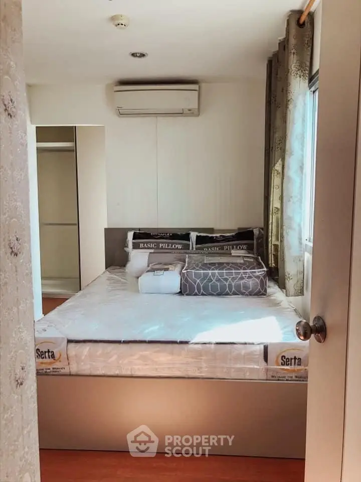 Cozy bedroom with air conditioning and ample natural light, featuring a comfortable bed and stylish decor.