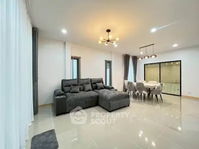 Spacious modern living room with elegant dining area and stylish lighting fixtures.