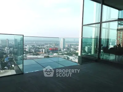 Stunning high-rise balcony with panoramic city views and modern glass railing.