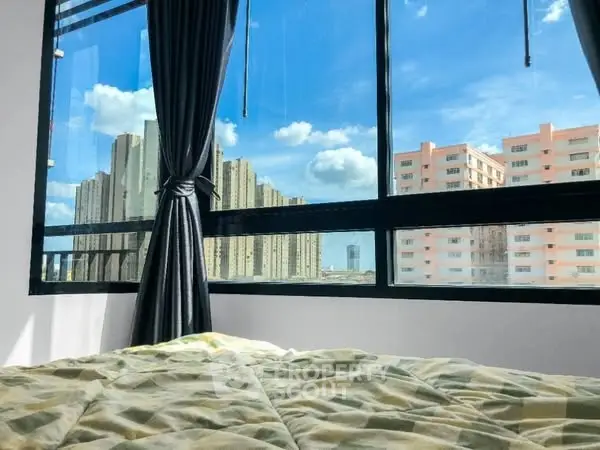Bright bedroom with large window offering stunning city views