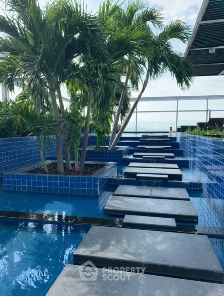 Luxurious rooftop pool with tropical landscaping and stunning views.
