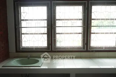 Charming bathroom with vintage sink and heart-patterned window grilles, perfect for a cozy home.