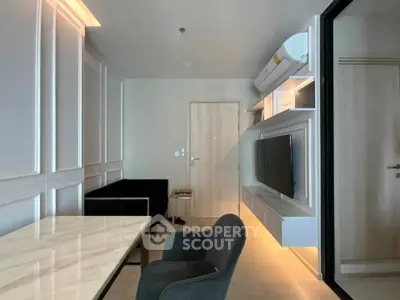 Modern living room with sleek furniture and wall-mounted TV in a stylish apartment.