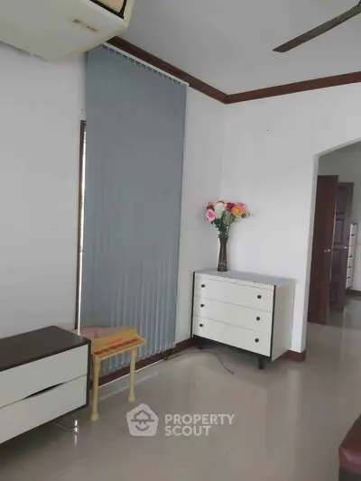 Cozy living room corner with modern furniture and decorative vase in a bright apartment.