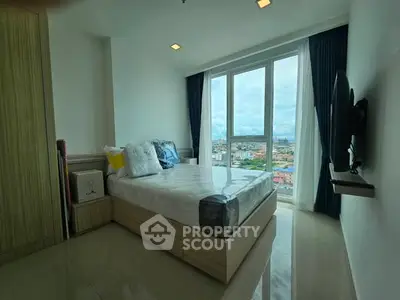 Modern bedroom with large window offering stunning city view, stylish decor, and natural light.