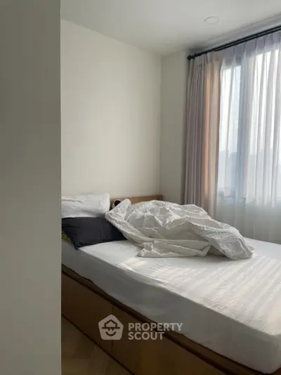 Cozy bedroom with natural light and modern decor, perfect for relaxation.