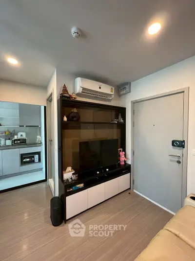 Modern living room with sleek entertainment center and open kitchen view