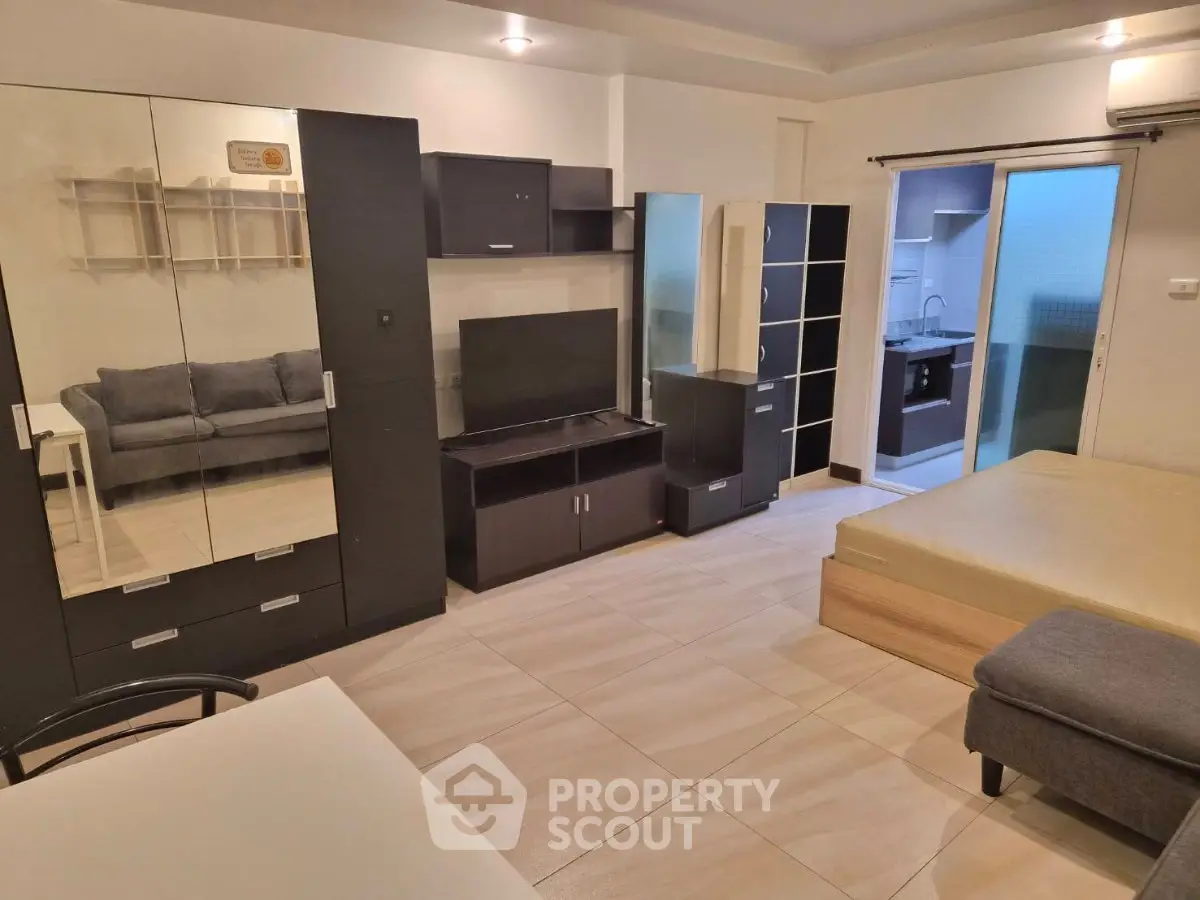 Modern studio apartment with sleek furniture and open layout, featuring a cozy living area and stylish decor.