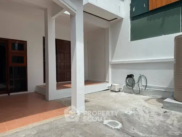 Spacious outdoor area with potential for customization, featuring tiled and concrete surfaces.