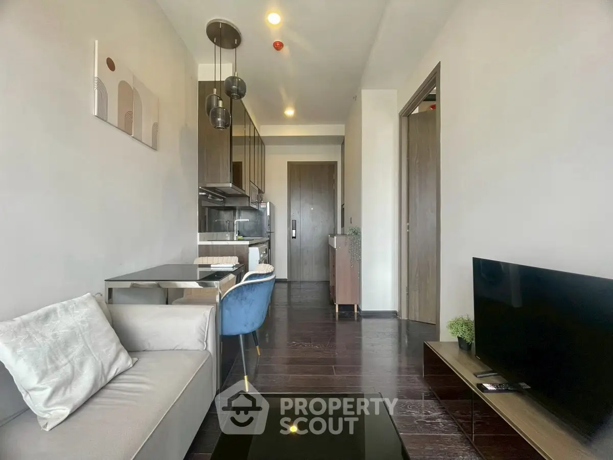 Modern living room with sleek furniture and open kitchen layout in a stylish apartment.