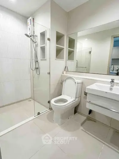 Modern bathroom with glass shower and sleek fixtures in a contemporary apartment.