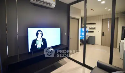 Modern living room with sleek TV setup and glass partition