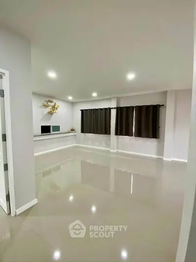 Spacious modern living room with glossy tile flooring and large windows.