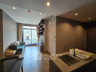 Modern living room with open layout and balcony view, featuring sleek furniture and contemporary design.