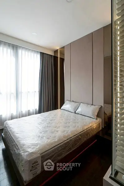 Modern bedroom with large windows and stylish decor, featuring a King Koil mattress for ultimate comfort.