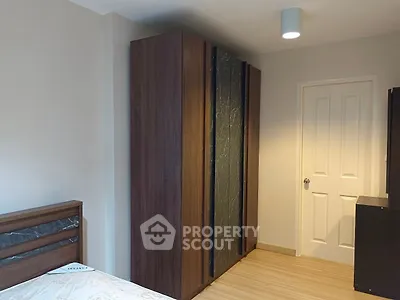 Modern bedroom with sleek wooden wardrobe and cozy lighting