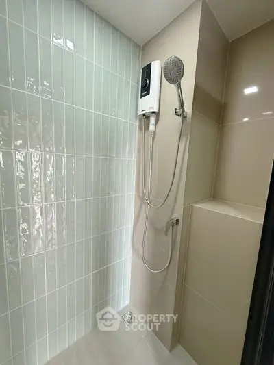 Modern bathroom shower area with sleek tiles and water heater installation.