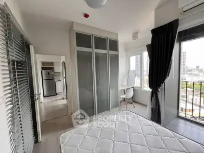 Bright bedroom with city view, modern wardrobe, and balcony access
