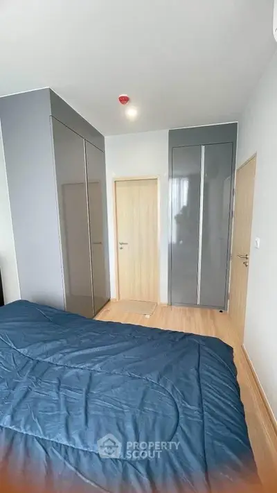 Modern bedroom with sleek wardrobe and wooden flooring