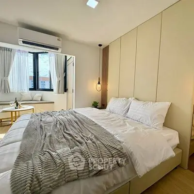 Luxurious bedroom with modern decor and large windows offering natural light.