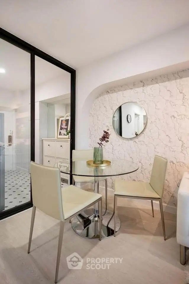Chic dining area with glass table and modern chairs in stylish apartment.