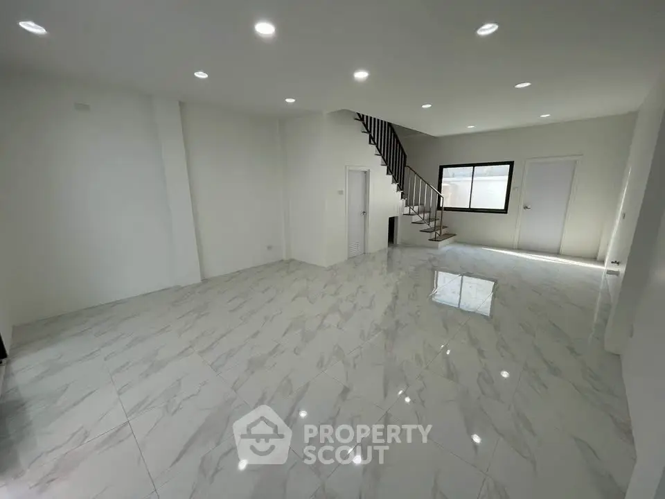 Spacious modern living room with elegant marble flooring and staircase