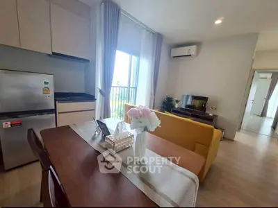 Modern living room with dining area, featuring a yellow sofa and stylish decor.