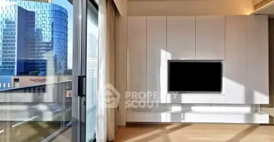 Modern living room with sleek built-in entertainment unit and city view from balcony.