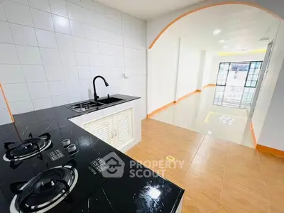 Modern kitchen with sleek black countertop and gas stove in open layout