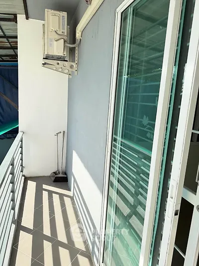 Charming balcony with sliding glass door and air conditioning unit, perfect for relaxation and fresh air.