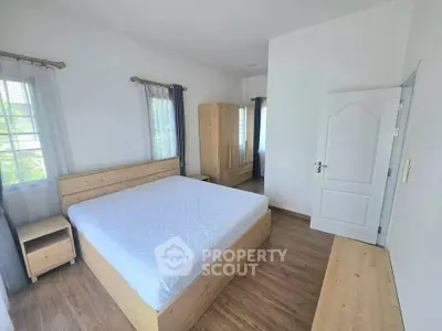 Spacious bedroom with wooden furniture and natural light
