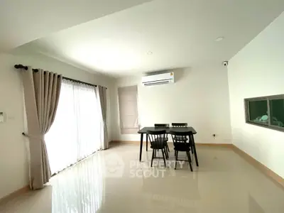 Spacious minimalist dining area with natural light and modern furnishings.