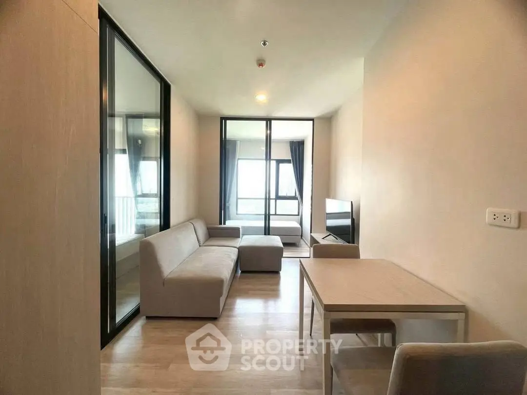 Modern living room with sleek furniture and large windows offering natural light.