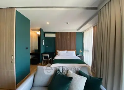 Modern bedroom with stylish decor and cozy seating area in a contemporary apartment.