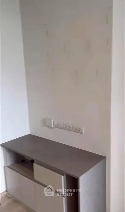 Modern minimalist interior with built-in storage and electrical outlets, ideal for efficient living spaces.