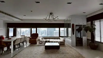 Spacious living room with panoramic city view and modern decor.
