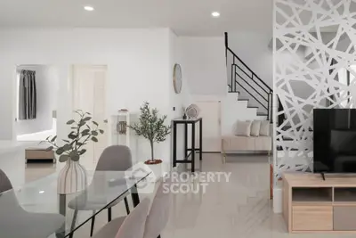 Modern open-plan living room with stylish decor and glass dining table
