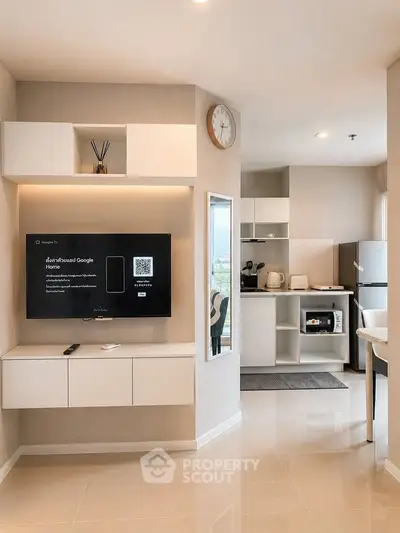 Modern open-plan living room and kitchen with sleek design and smart TV setup.