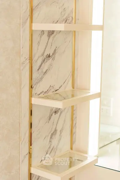 Elegant marble shelves with gold accents in a luxurious bathroom setting.