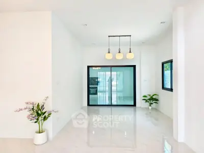 Spacious modern living room with elegant lighting and marble flooring, featuring large windows and stylish decor.