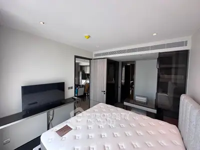 Modern bedroom with sleek design and large TV, perfect for comfort and relaxation.