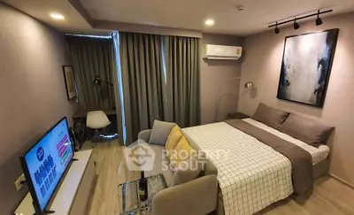 Modern studio apartment with cozy living area and stylish decor, featuring a comfortable bed and wall-mounted TV.