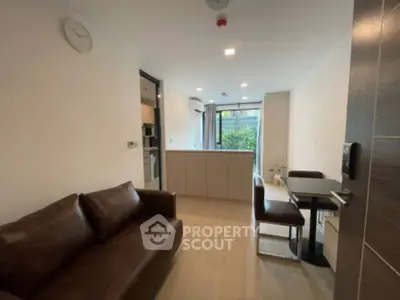 Modern living room with brown leather sofa and dining area in open layout apartment.
