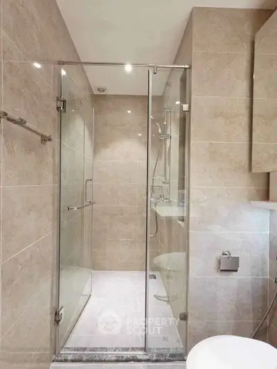 Modern bathroom with glass shower enclosure and elegant tile design
