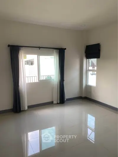 Spacious empty room with large windows and tiled floor, perfect for customization.