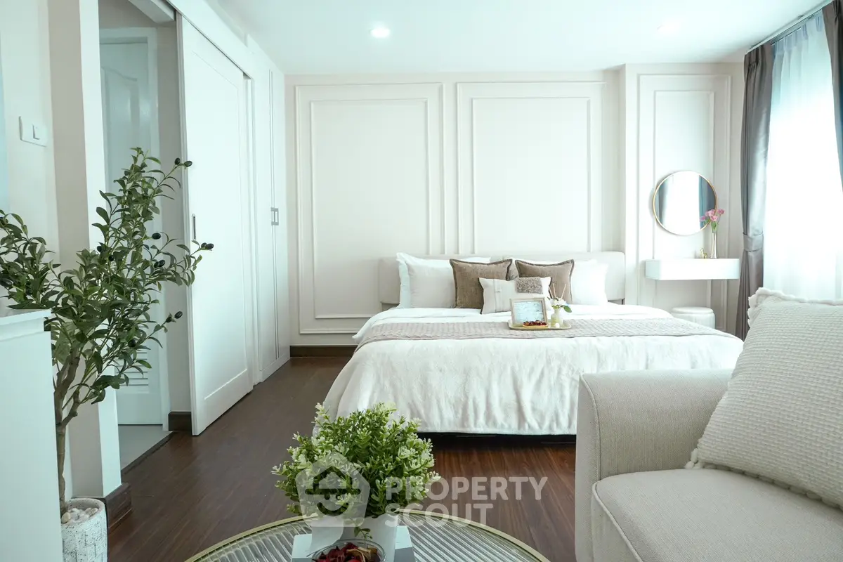 Elegant bedroom with modern decor and natural light, featuring cozy bed and stylish furnishings.