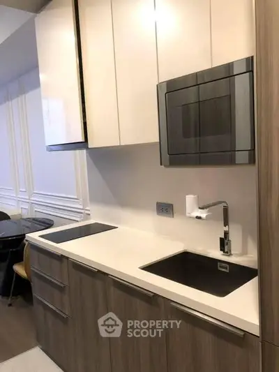 Modern kitchen with sleek cabinetry and built-in microwave